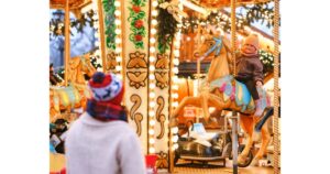 childs are enjoying in shiny Christmas market at night