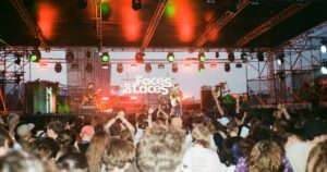 Live-Band auf der Faces & Laces Bühne mit rot-grünem Licht und begeisterter Menge bei einem Electro-Festival