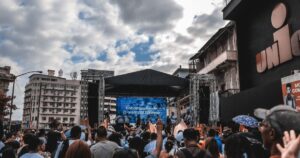 Große LED-Bühne mit jubelnder Menge unter bewölktem Himmel in der Stadt bei einem Electro-Festival 2025