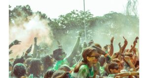 Jubelnde Menge mit grünem und pinkem Farbpulver in der Luft bei einem Electro-Festival