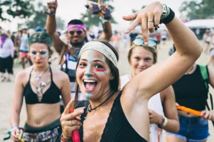 Fröhliche Raverinnen bei Techno-Festival 2025: buntes Facepaint, Festival-Bändchen und Peace-Zeichen – Sommer-Vibes, Gemeinschaftsgefühl und pure Lebensfreude im Freien.
